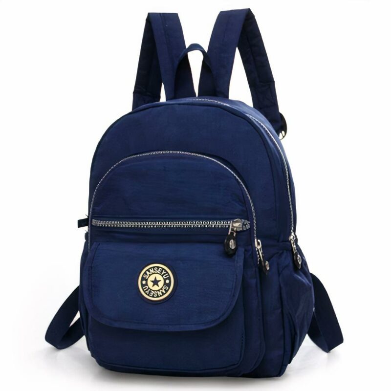 Mini zaino impermeabile da donna in tinta unita blu navy. Lo zaino ha quattro tasche di dimensioni diverse. Una con velcro e 3 con cerniera. La tasca in velcro presenta il logo della borsa. La borsa è dotata di una maniglia per tenerla al gancio e di due cinghie per portarla sulla schiena.