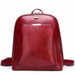 Piccolo zaino vintage in similpelle rossa tinta unita con sfondo bianco