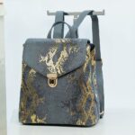 Zaino da donna in pelle con motivo pitonato, di buona qualità e alla moda su una gruccia