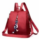 Zaino Oxford rosso da donna con ciondolo e sfondo bianco