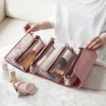 Borsa cosmetica multitasche rosa e trasparente per donne con una donna che sceglie la borsa sul fondo