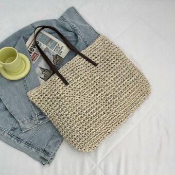 Borsa da spiaggia in paglia intrecciata bohémien per una donna beige con letto bianco e giacca in denim