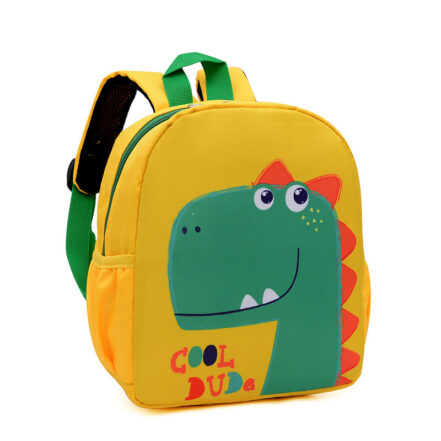 Uno zaino per bambini giallo e verde con un dinosauro verde con piccole scaglie arancioni. Lo zaino ha uno sfondo bianco. Ha due spallacci colorati sul retro.