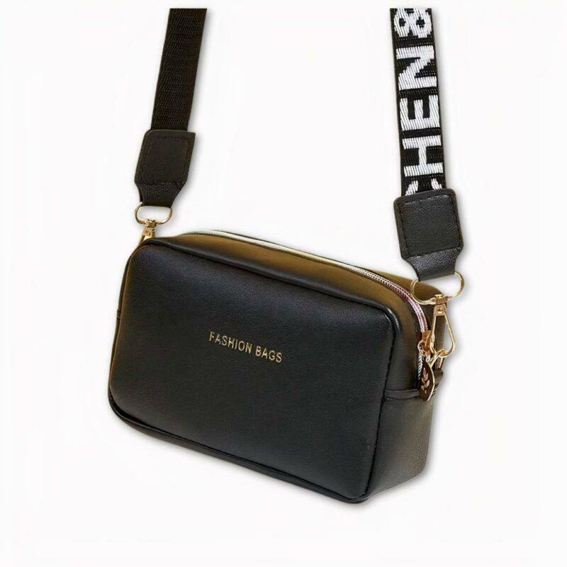 Foto di una borsa a tracolla da donna. Di colore nero, è appesa ad una tracolla nera con scritta bianca. La tracolla è rimovibile e sulla parte anteriore della borsa si legge 'Fashion bags'. La cerniera e i moschettoni sulla tracolla sono dorati. Lo sfondo è grigio chiaro.