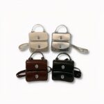 4 piccoli zaini da donna. Beige, grigio, marrone e nero, su sfondo grigio chiaro