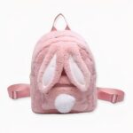 Zaino per bambini in peluche rosa con orecchie da coniglietto e coda a pom-pom sul davanti.